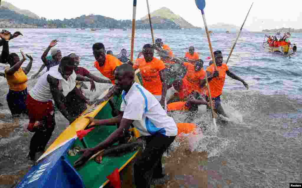 Revelers cheer participants during the traditional Kafuke boat-racing festival, as part of the Christmas celebrations, in Lake Victoria at Budalangi&#39;s Marenga beach in Port Victoria of Bunyala Sub-County of Busia, Kenya.