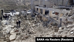 Sejumlah petugas memeriksa bangunan yang roboh setelah Media Pemerintah Suriah melaporkan serangan udara oleh Israel terhadap Damaskus, Suriah, 7 Maret 2022. (Foto: SANA via Reuters)