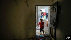 A boy enters an apartment after a military raid in the Nur Shams refugee camp near Tulkarem, in the West Bank, May 6, 2023. Israeli forces killed two Palestinians in the raid.