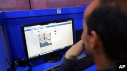 FILE - A man accesses Facebook at an internet cafe in Kabul, Afghanistan, Feb. 10, 2016. A Taliban telecommunications official says a policy restricting or banning access to Facebook in Afghanistan is being prepared.