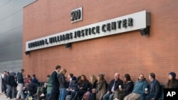 People including those planing to attend the Dominion Voting Systems' defamation lawsuit against Fox News wait to enter the justice center in Wilmington, Del., Tuesday, April 18, 2023.