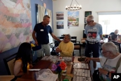 Stonewall Gardens employee Brian Trout, second from left, leads a game of bingo with residents of the LGBTQ assisted living facility on Aug. 15, 2023, in Palm Springs, California.