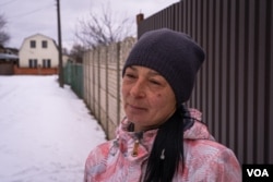 Ludmila speaks in Nova Kozacha, Ukraine, Feb. 14, 2023. Her husband has been in Russia since August when the shrapnel of a bomb injured him. She says he wants to come back, but it is impossible to cross the border. (Yan Boechat/VOA)
