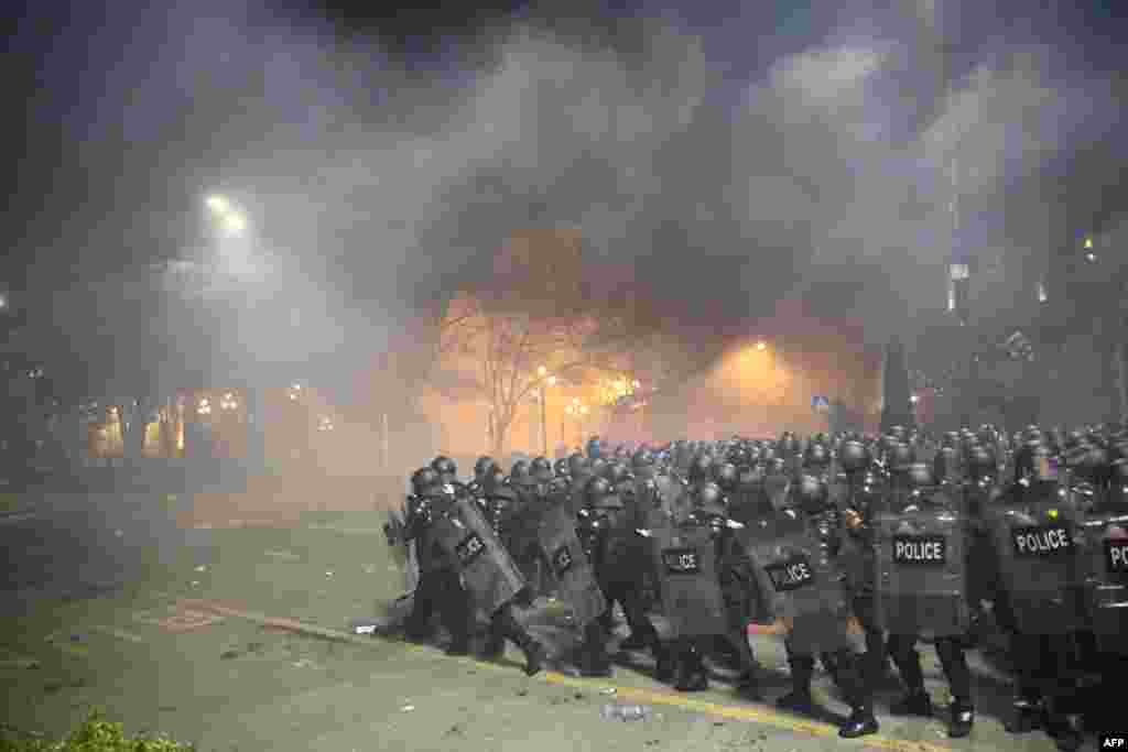 Police in riot gear face protesters in Tbilisi, Georgia, March 8, 2023.&nbsp;Police fired water cannon and tear gas to disperse thousands of protesters who rallied against a planned &quot;foreign agent&quot; law reminiscent of Russian legislation used to silence critics.