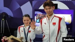 Peraih medali emas ganda campuran bulutangkis China Huang Yaqiong memamerkan cincin pertunangannya setelah rekan satu timnya, Liu Yuchen melamarnya pada upacara penyerahan medali di Paris, 2 Agustus 2024.