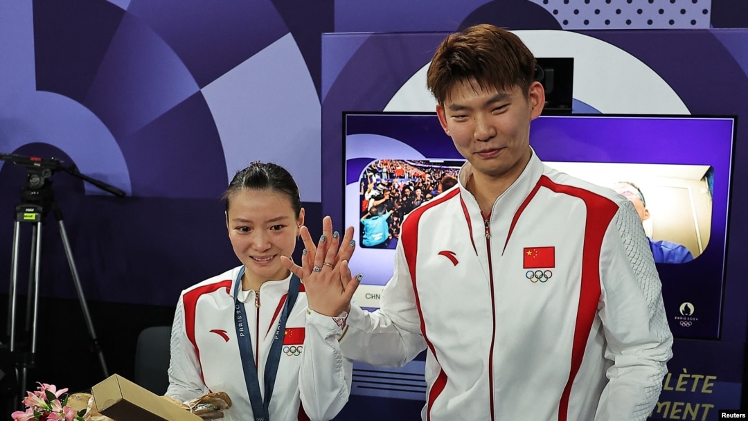 Chinese badminton mixed doubles gold medalist Huang Yaqiong shows off her engagement ring after teammate Liu Yuchen proposed to her at the medal ceremony on Aug. 2, 2024, in Paris.