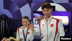 Chinese badminton mixed doubles gold medalist Huang Yaqiong shows off her engagement ring after teammate Liu Yuchen proposed to her at the medal ceremony on Aug. 2, 2024, in Paris.