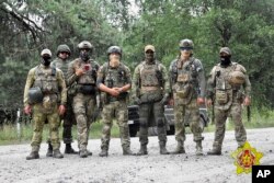 Tentara Belarus dan tentara bayaran Grup Wagner berpose di Kota Brest, di perbatasan Belarus, 20 Juli 2023. (Foto: Kementerian Pertahanan Belarus via AP)