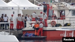 Rescue personnel work next to the body bag containing the corpse of British entrepreneur Mike Lynch, who died when a yacht owned by his family sank off the coast of Porticello, near the Sicilian city of Palermo, Italy, Aug. 22, 2024. 