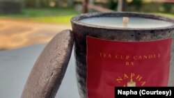 ພາບທີ່ໄດ້ຮັບການສະໜອງ ຈາກ Napha Tea Cup Candle, ເຊິ່ງນໍາໃຊ້ຈອກຫິນ ທີ່ເປັນເຄື່ອງປັ້ນດິນເຜົາ ຂອງສູນແມ່ຍິງພິການ ໃນນະຄອນຫຼວງວຽງຈັນ.