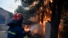 A firefighter works to extinguish the flames at a burning house in northern Athens, Aug. 12, 2024, as hundreds of firefighters tackle a major wildfire. Dry pine forests and strong winds have aided the fire, making it difficult for firefighters to get the blaze under control.  