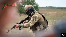 FILE - In this video still released by Belarusian Defense Ministry via VoenTV on July 14, 2023, a member of the Wagner Group shows his skills to Belarusian soldiers during a training near Tsel. Niger's military junta has reportedly asked for help from the Russian mercenary group.