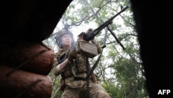 A Ukrainian soldier of the 28th Separate Mechanized Brigade fires towards Russian positions at the front line near the town of Bakhmut, Donetsk region, on June 17, 2023, amid the Russian invasion of Ukraine.