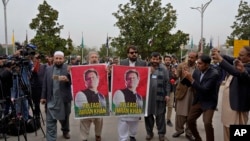 파키스탄 신임 연방하원들이 29일 개원하는 이슬라마바드 연방의회에 도착해 임란 칸 전 총리의 포스터를 들고 석방을 촉구하고 있다. (자료사진)