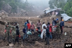 FILE - Malawi Defense Force soldiers and civilians work to recover body of a victim of a mudslide from heavy rains after Cyclone Freddy during a rescue operation in Blantyre, Malawi, March 17, 2023.