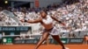 FILE - Coco Gauff plays a shot against Poland's Iga Swiatek during their semifinal match of the French Open tennis tournament at the Roland Garros stadium in Paris, June 6, 2024. Gauff will join LeBron James as a flag bearer for the US Olympic team at Friday's opening ceremony.