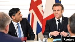 Presiden Prancis Emmanuel Macron (kanan) dan Perdana Menteri Inggris Rishi Sunak dalam pertemuan dengan perusahaan Prancis dan Inggris, sebagai bagian dari KTT Prancis-Inggris di Paris, 10 Maret 2023. (Emmanuel Dunand/Pool via REUTERS)