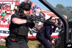 Secret Service mengelilingi panggung saat agen lainnya melindungi calon presiden dari Partai Republik, mantan Presiden Donald Trump, pada rapat umum kampanye, Sabtu, 13 Juli 2024, di Butler. (Foto: AP)