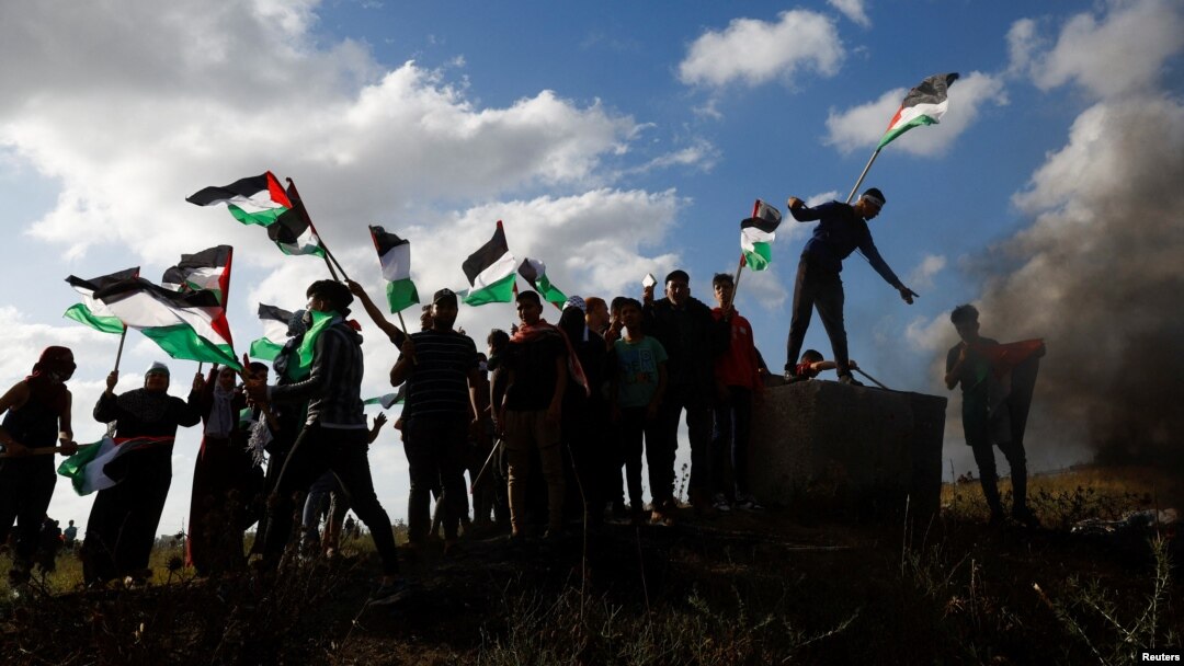 Warga Palestina melakukan aksi protes menentang diadakannya pawai bendera tahunan oleh warga Yahudi pada perayaan “Hari Yerusalem,” yang menandai penaklukan Israel atas Kota Tua itu 56 tahun lalu, di Jalur Gaza hari Kamis (18/5). 