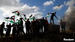 Warga Palestina melakukan aksi protes menentang diadakannya pawai bendera tahunan oleh warga Yahudi pada perayaan “Hari Yerusalem,” yang menandai penaklukan Israel atas Kota Tua itu 56 tahun lalu, di Jalur Gaza hari Kamis (18/5). 