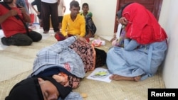 Rohingya Muslim refugees rest at the Samatiga District Office after Indonesian fishermen rescued dozens after high tides capsized their boat in waters off the West Aceh, in Aceh province, Indonesia, March 20, 2024, in this photo taken by Antara Foto.