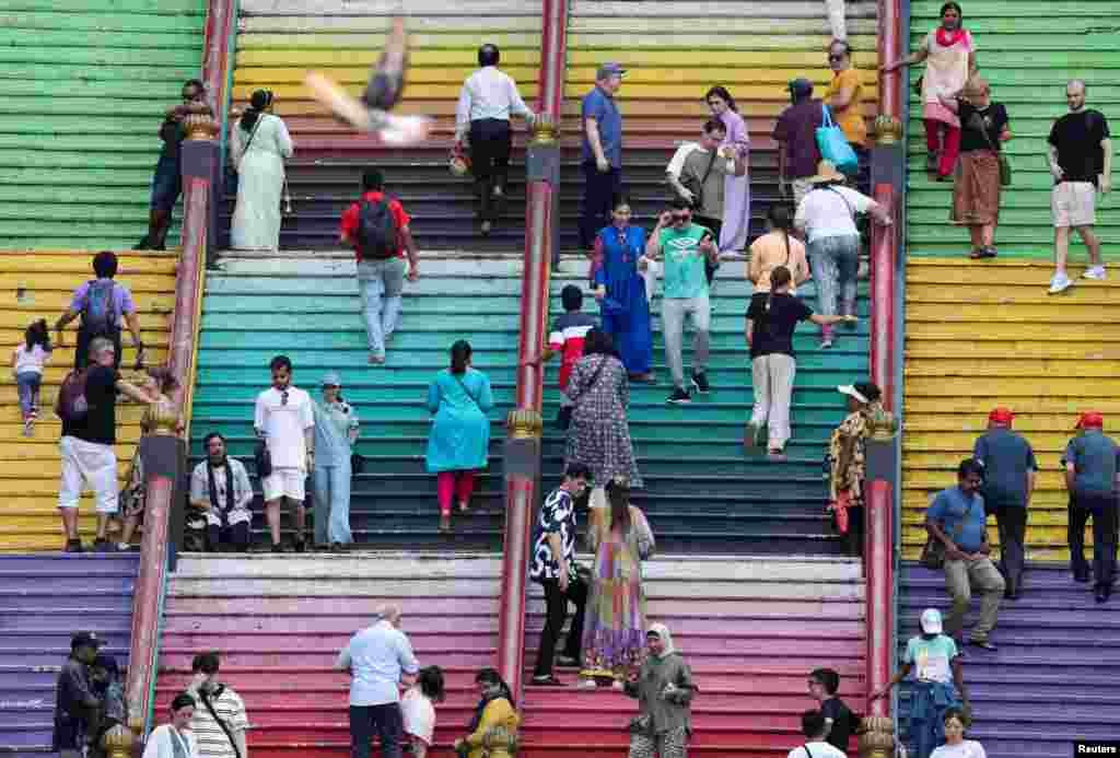 Visitors and Hindu devotees are seen on the 272 steps of Sri Subramaniar Swamy Temple at Batu Caves, Malaysia.