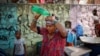 FILE - A woman pours water on her head after filling her containers with drinking water from a municipal tanker on a hot summer day in New Delhi, India, May 21, 2024.