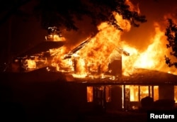 A burning house is seen as Park Fire burns near Chico, California, July 25, 2024.