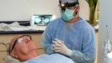 FILE - In this photo made June 26, 2009, Costa Rican Dr. Luis Obando, right, prepares to perform a root canal on Bill Jones, of Dallas, Texas at Meza Dental Care in San Jose, Costa Rica. (AP File photo)