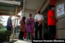 Para pemilih antre untuk memasukkan surat suara dalam pemilu negara bagian di Selayang, Malaysia, Sabtu, 12 Agustus 2023. (Foto: Hasnoor Hussain/Reuters)