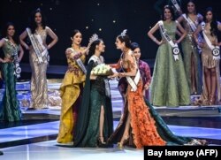 Miss Universe Filipina Catriona Grey (C kanan) mengantarkan bunga kepada pemenang kontes kecantikan Indonesia 2019, Frederika Alexis Cull (C), di Jakarta, pada 8 Maret 2019. (Foto: AFP/Bay Ismoyo)