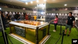 Fans stand next to the tomb of the late Brazilian soccer great Pele which became open to the public for the first time, at the mausoleum of Necropole Ecumenica Memorial Cemetery in Santos, Brazil on Monday, May 15, 2023.