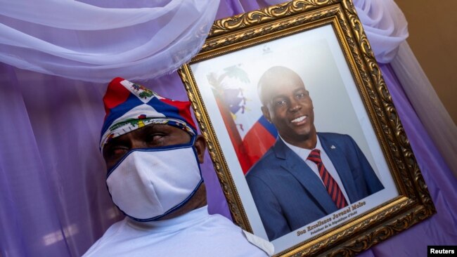 Un hombre aparece junto a un retrato del asesinado presidente haitiano, Jovenel Moïse, colocado en un monumento en el ayuntamiento de Cabo Haitiano, Haití, el 22 de julio de 2021. [REUTERS]