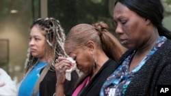 People stand outside a commercial building after a shooting, in Atlanta, May 3, 2023.