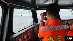 Anggota penjaga pantai Taiwan memeriksa sebuah perahu di wilayah utara lepas pantai Taiwan pada 23 Mei 2024. (Foto: Handout/Taiwan Coast Guard/AFP)