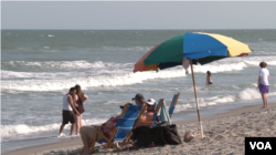 People enjoy the sun and the beach in Cocoa Beach, Florida, March 2, 2023. (Photo by Adam Greenbaum/VOA)
