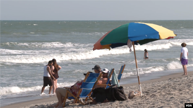 People enjoy the sun and the beach in Cocoa Beach, Florida, March 2, 2023. (Photo by Adam Greenbaum/VOA)