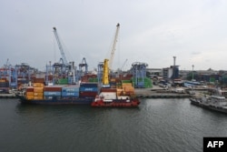 Peti kemas sedang dimuat ke sebuah kapal kargo di Pelabuhan Tanjung Priok, Jakarta, 28 Maret 2023. (Foto: Adek Berry/AFP)