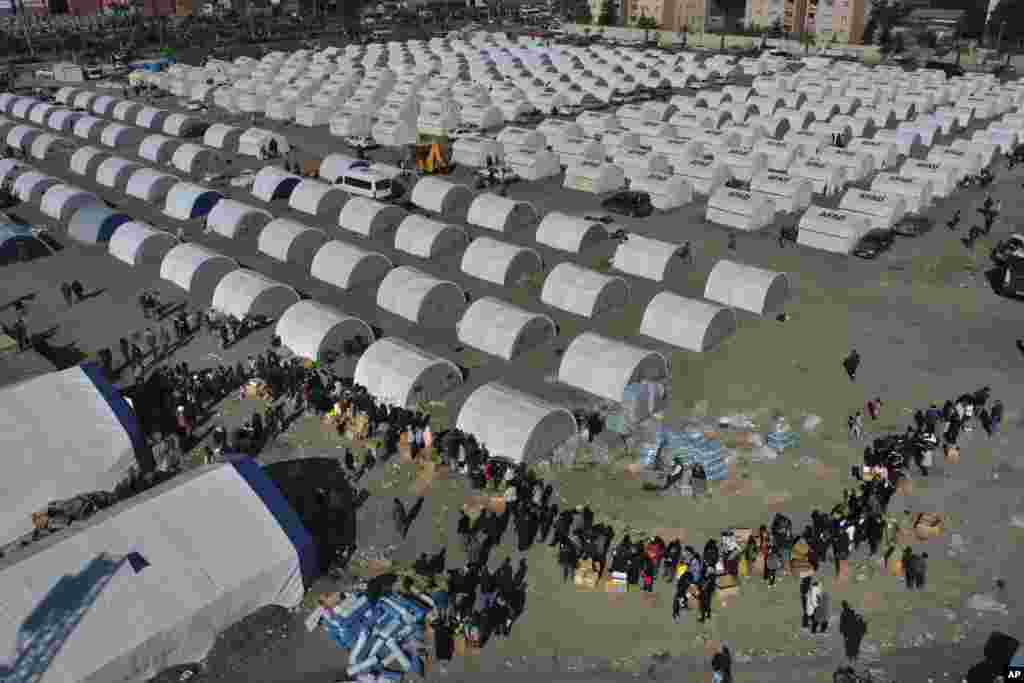 People who lost their houses in the devastating earthquake, lineup to receive aid supplies at a makeshift camp in Iskenderun city, southern Turkey.