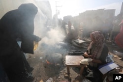 Palestinian women bake bread outside a U.N-run school in Rafah, Gaza Strip, Oct. 27, 2023.