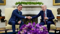 El presidente Joe Biden, a la derecha, le da la mano al presidente de España, Pedro Sánchez, en una reunión en la Oficina Oval de la Casa Blanca en Washington, el 12 de mayo de 2023.