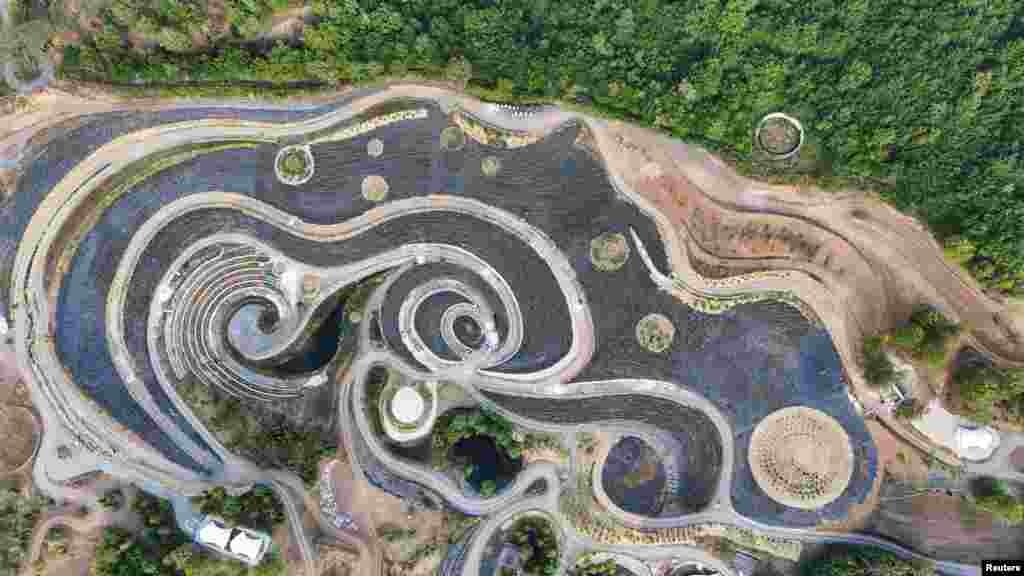 A drone view of a park transformed into a replica of Vincent Van Gogh&#39;s famous painting &#39;Starry Night,&#39; featuring fields of lavender, shrubs, and lakes connected by an array of paths, in Visoko, Bosnia and Herzegovina.