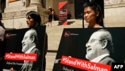 FILE - People listen as writers gather to read selected works of British author Salman Rushdie, one week after he was stabbed while on stage, during a rally to show solidarity for free expression outside the New York Public Library, Aug. 19, 2022. 