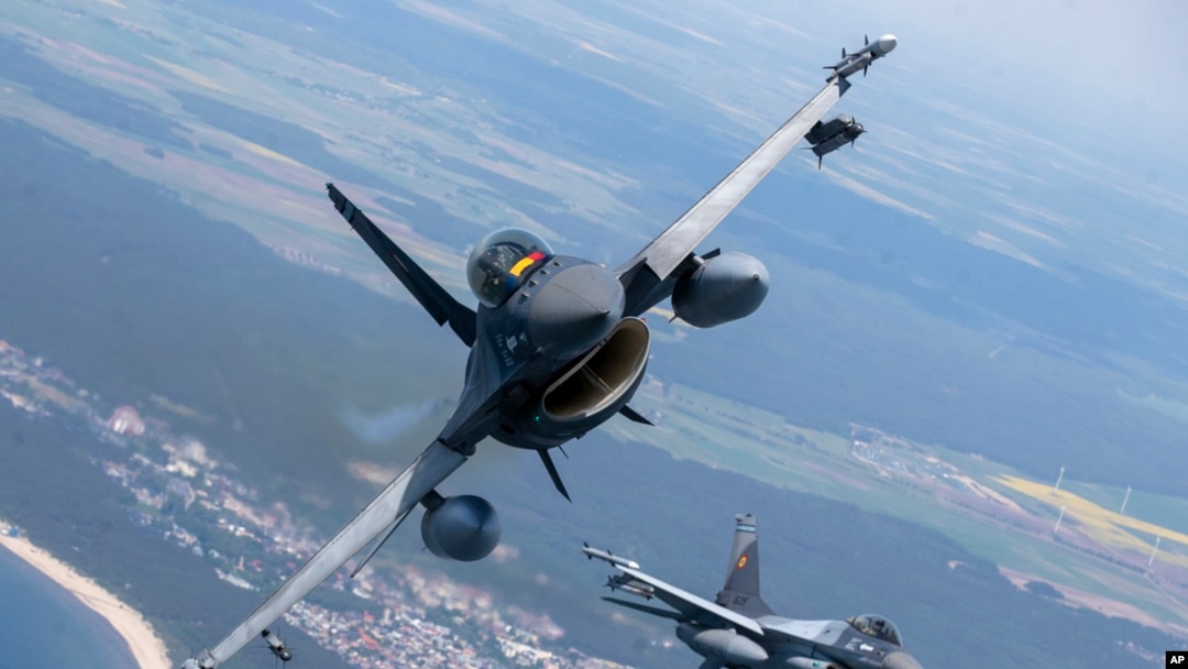 FILE - A Romanian Air Force F-16 military fighter jet, left, and a Portuguese Air Force F-16 military fighter jets participating in NATO's Baltic Air Policing Mission operate over the Baltic Sea, on May 22, 2023. 