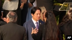 El vicepresidente de Taiwán, William Lai, habla con una mujer no identificada antes de la ceremonia de investidura del presidente de Paraguay, Santiago Peña, en Asunción, el 15 de agosto de 2023.