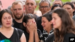 Mourners weep during a funeral in the village of Malo Orasje, Serbia, for five people killed during the country's second mass shooting in two days, May 6, 2023.