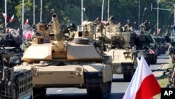 পোল্যান্ডের কেনা যুক্তরাষ্ট্রের তৈরি আব্রামস ট্যাঙ্কগুলো পোল্যান্ডের ওয়ারশতে একটি সামরিক কুচওয়াজে অংশ নেয়। ১৫ আগস্ট, ২০২৩। ফাইল ছবি।