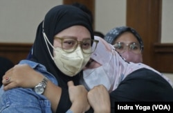 Savitri Puspa Rani (kiri), orang tua korban gagal ginjal akut yang anaknya meninggal pada usia 8 tahun menangis harus setelah mendengar putusan majelis hakim dalam sidang lanjutan class action pada Selasa (21/3) di Pengadilan Negeri Jakarta Pusat. (VOA/Indra Yoga)