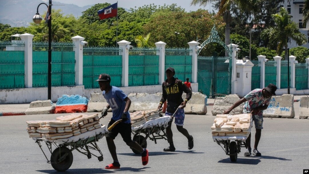 Para pedagang kaki lima melarikan diri dari area tempat mereka berjualan roti, dekat Istana Nasional, di Port-au-Prince, Haiti, Selasa, 2 April 2024. (Foto: Odelyn Joseph/AP Photo)