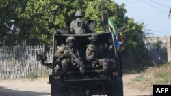 Un convoi militaire des Forces de défense nationale sud-africaines (SANDF) circule sur un chemin de terre dans le district de Maringanha à Pemba, le 5 août 2021.